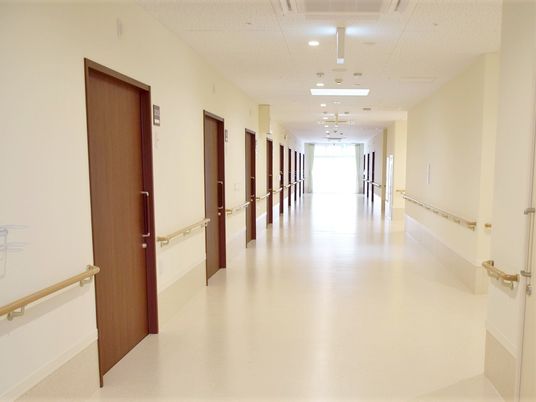 手すりが取り付けられた施設内の廊下。幅が広めで通りやすい仕様になっている