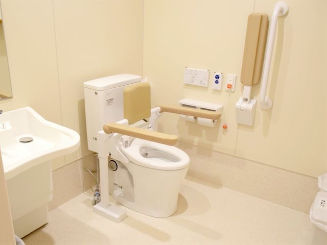 バリアフリートイレ設備 トイレ 手すりと便座昇降機能のついた清潔なトイレです。快適で安全な使い心地を考えた設計になっております。