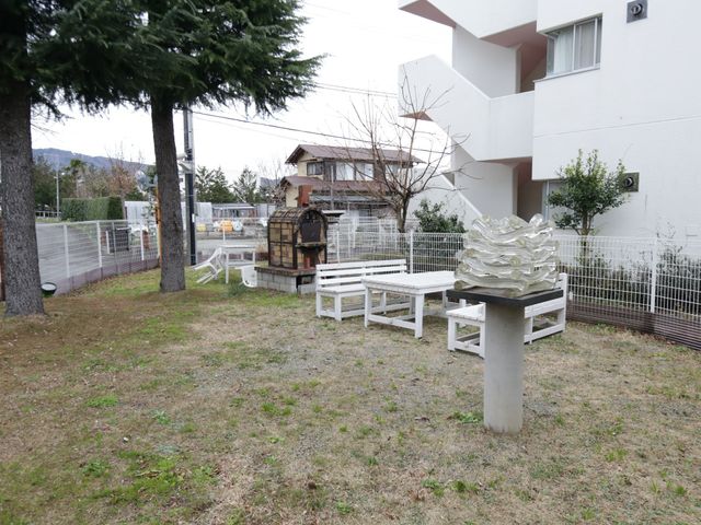 白いベンチのある中庭 庭 ゆったりと過ごせる中庭には、木々やオブジェが配置され、静かな時間を楽しむことができます。白いベンチが置かれ、穏やかな休息を提供しています。