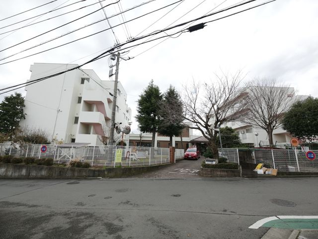 建物と門の景色 外観 白い壁が印象的な建物の前には、開放感のある敷地が広がっており、訪れる方を優しく迎え入れます。安心してお仕事をスタートできる環境です。