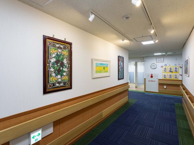 アート作品が飾られた廊下 廊下 壁に美しいアートが並ぶ明るい通路です。温かみのある空間が広がっています。