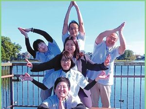屋外でポーズを取る職員と利用者  
