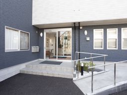 青と白の外壁のエントランス