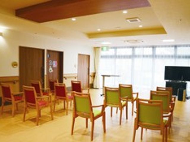 自然光が入る広間 多目的室 広々とした多目的室で、自然光が差し込み心地よい空間です。椅子が並び、集会に適しています。