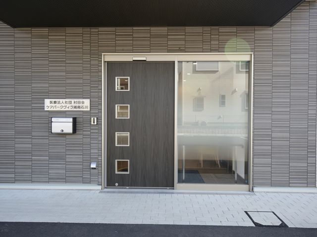 モダンな建物のエントランス エントランス 清潔感のあるエントランスで、明かりが差し込む開放的な雰囲気が迎え入れます。訪問者に安心感を与えるデザインです。