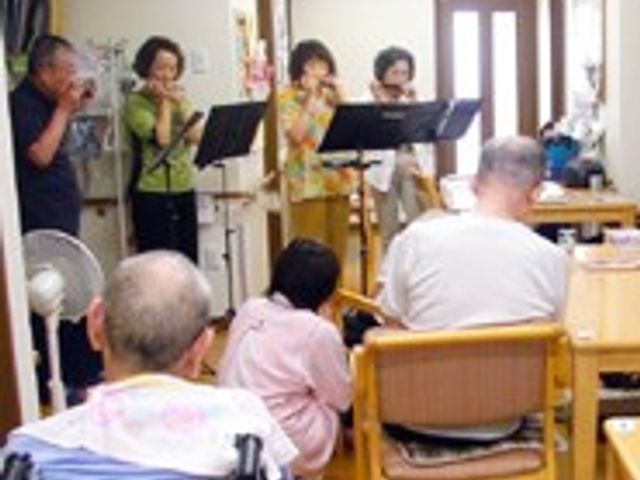 演奏が行われている居室 居室   演奏が行われている居室では、利用者さんとスタッフがリラックスした雰囲気で音楽を楽しんでいます。