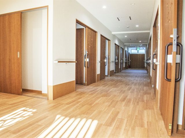 廊下の明るい空間 廊下 広く明るい廊下が、ゆったりと歩けるよう配慮されています。安全ハンドレールも設置され、利用者の快適な移動を支えています。