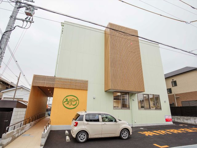 施設の明るい外観 外観 清潔感あふれる明るい建物が、新しい職場への期待を膨らませます。駐車スペースも完備され、利便性を備えています。