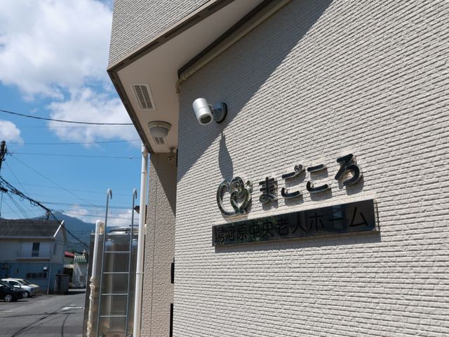 施設外観の看板 外観   青空の下、建物の壁面に施設名の看板が掲げられています。周囲は落ち着いた住宅街の雰囲気です。