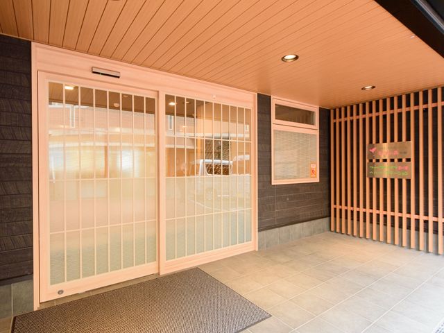 明るいエントランス 玄関 ゆったりとしたエントランスには、暖かみのある照明が設置され、心地よい雰囲気を演出しています。