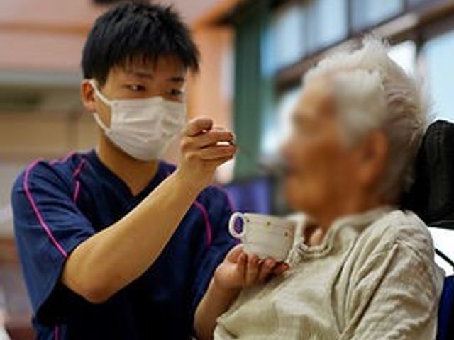お食事支援の様子 スタッフイメージ   スタッフが利用者にお食事を提供しています。暖かな雰囲気が感じられます。