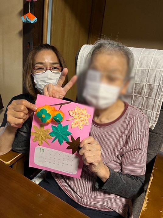 作品を持つ女性二人の様子