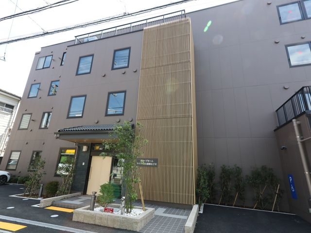 モダンな建物のエントランス 外観 心地よく働ける環境が整った、清潔感あふれるエントランスです。駐車スペースも確保され、アクセスも良好です。