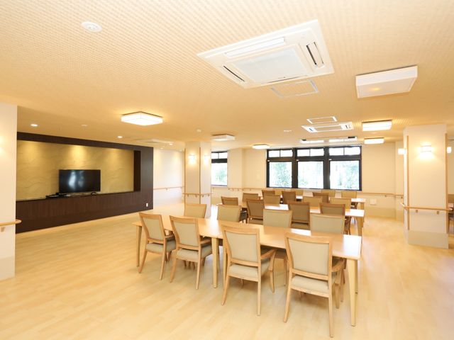 快適な共有スペース 共有スペース ゆとりあるダイニングで、利用者様が穏やかな食事の時間を過ごされています。明るく清潔感のある空間設計になっており、快適にお過ごしいただけます。