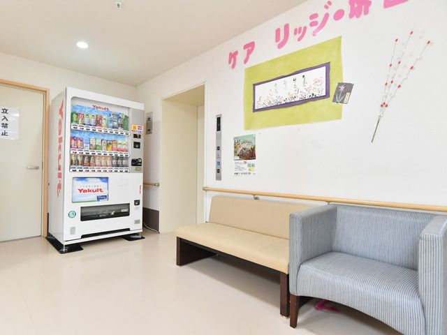 休憩スペースと自動販売機 エレベーター リラックスできるソファと飲料の自動販売機が設置され、ちょっとした休息に適したコーナーです。