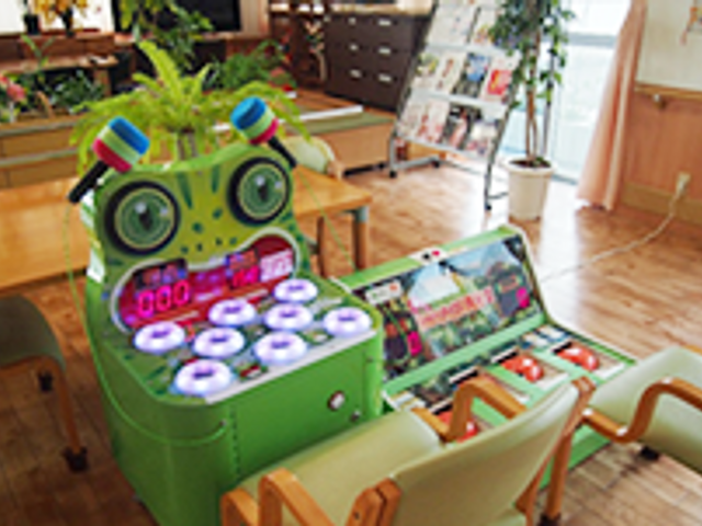 植物付きの遊戯台 多目的室 カラフルな遊戯台が置かれた心温まる多目的スペース。社交や娯楽を楽しむ様子が想像されます。