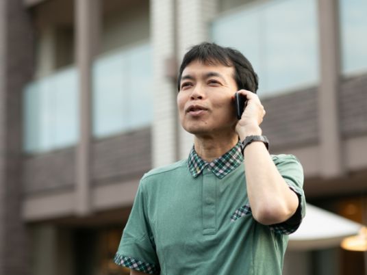 屋外で通話する男性スタッフ  
