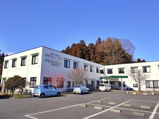 車が停まる白い建物
