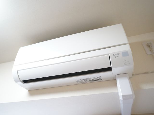 壁掛けエアコンのクローズアップ エアコン 清潔感あふれる室内で、快適な空調が整えられています。働く環境の快適性を大切に考慮している様子が伺えます。