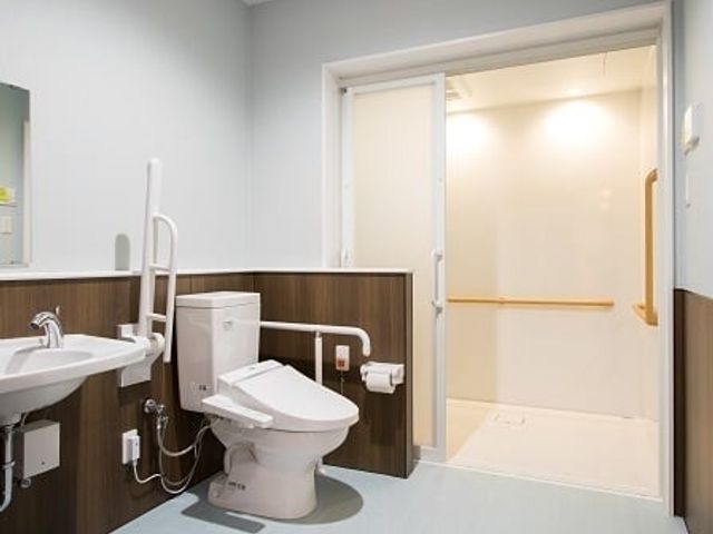 手すり付きの清潔なトイレ トイレ 明るく清潔な空間で、手すりが設置されています。利用者が安心して使える配慮がなされています。