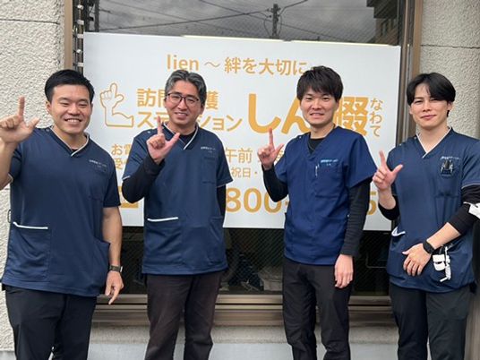 スタッフが並ぶ看板前  