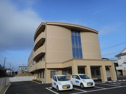 広々駐車場と建物外観