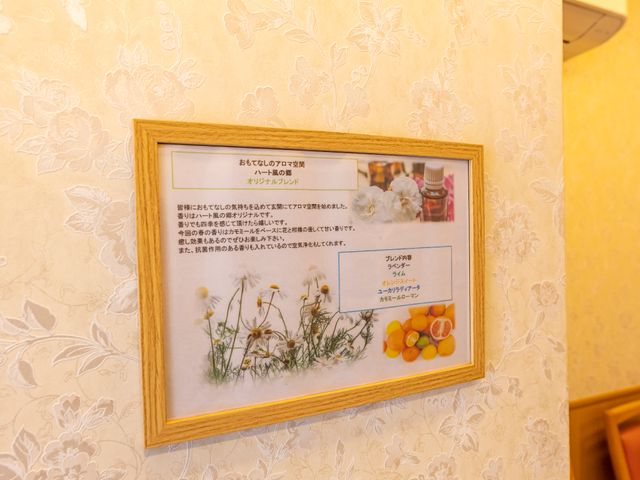 壁掛けの掲示物 アロマ 暖かみのある壁紙に飾られた、心地良い生活空間を予感させる掲示物です。お仕事中もほっと一息つける場所がそばにあります。