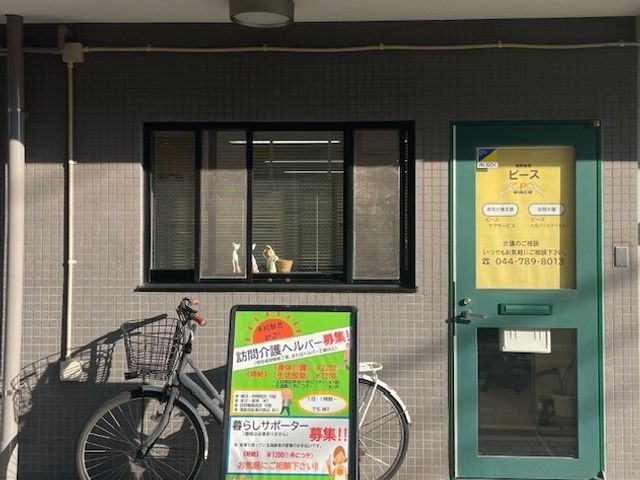 入口と看板 外観 玄関先には自転車置き場が設けられており、動きやすい環境が整っています。看板には募集情報が記載されています。