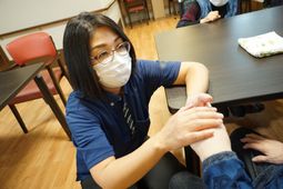 施設スタッフが手を握る様子