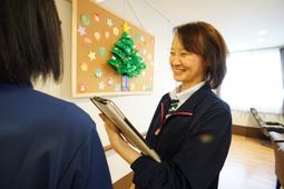 職員と掲示物のやり取り
