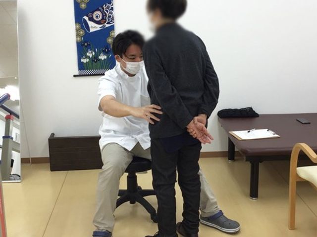 介護訓練室内の風景 機能訓練室 介護士が利用者の身体をサポートし、リラックスした雰囲気で機能訓練を行っています。
