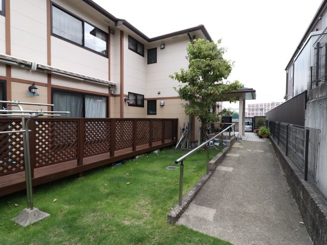 庭の眺める通路 入口 庭木が風に揺れる、ゆったりとした通路が特徴の外の空間です。散歩や憩いのひと時を提供しております。