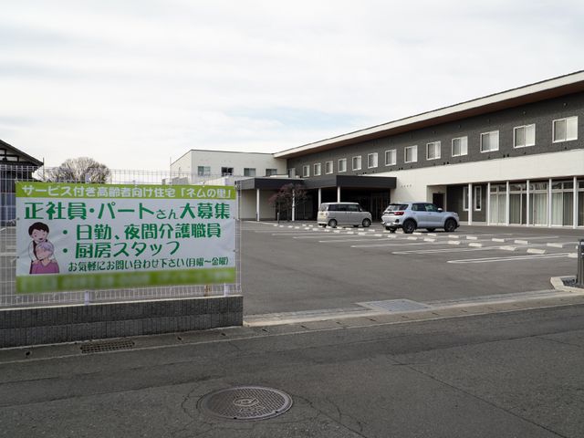 ゆったりとした外観の建物 外観 広々とした駐車場があり、バリアフリーでアクセスしやすい建物です。将来的な職場環境としては快適な場所でしょう。