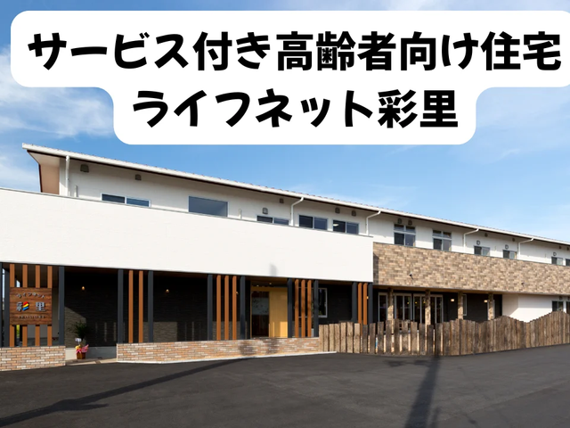 サービス付き高齢者向け住宅の外観 外観   白を基調とした建物で、木目の縦格子がアクセントになっています。広い駐車スペースもあり、落ち着いた印象です。