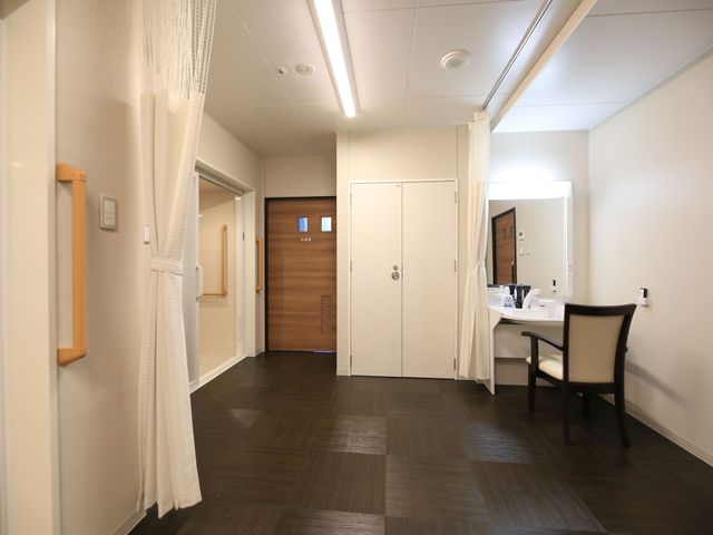 清潔な室内の一角 共有スペース ゆったりとした洗面台の備えられた居室で、日々の準備が心地よい時間になります。廊下には手すりがついており、安心して歩行できる環境です。