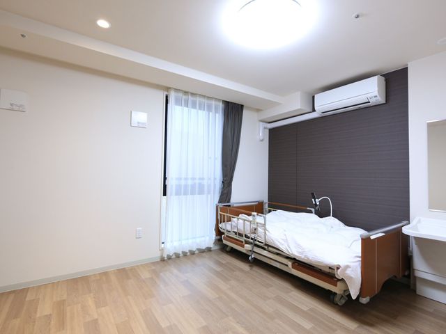 清潔な居室の一角 居室  ゆったりとしたベッドスペースのある居室です。明るく清潔な空間でゆっくりお過ごしいただけます。