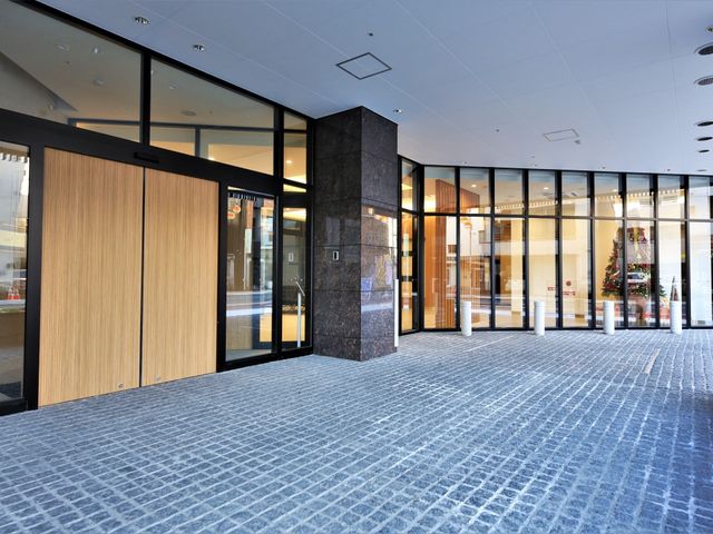 広々としたモダンなエントランス 玄関  開放的でモダンなデザインの入口は、明るくて招待感のある空間を創出しており、訪れる人々を温かく迎え入れます。