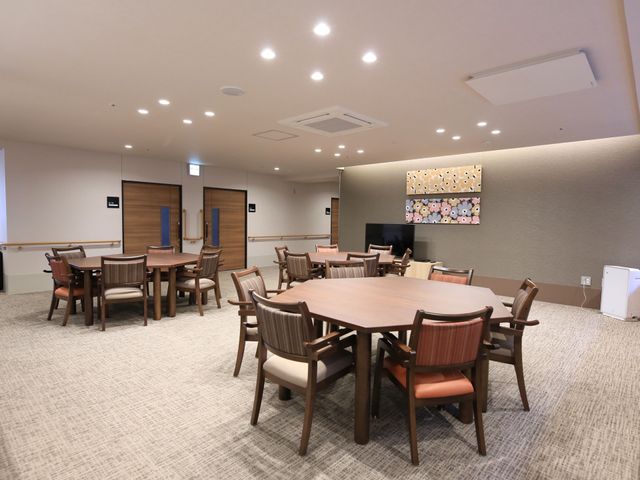 広々とした明るい食堂 共有スペース  木の温もりが感じられる食堂で、共に食事を楽しみながら交流を深めることができます。空間は清潔感があり、ゆったりと配置されたテーブルと椅子があります。