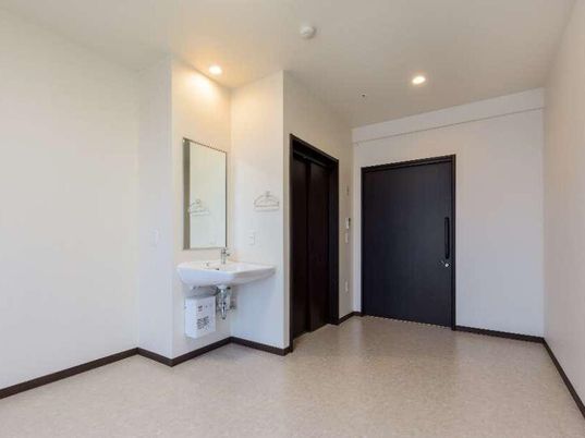 白壁の洗面台と入口