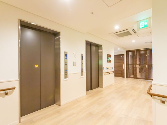 明るい廊下とエレベーター 廊下 明るい廊下にエレベーターがあり、施設内の移動がしやすくなっています。エアコンも完備され、快適な環境です。