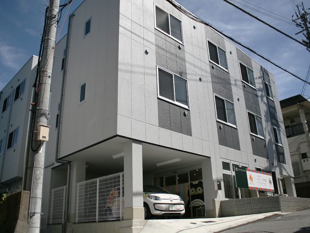 モダンな外観の建物 外観 新しい建物のエントランスは広々としており、明るい雰囲気を醸し出しています。イラスト入りの看板が訪れる方を温かく迎えています。