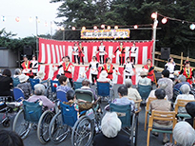 イベントの様子 中庭 屋外イベントが活気に満ちています。入居者とスタッフが一緒に楽しむ温かい雰囲気を感じ取れます。