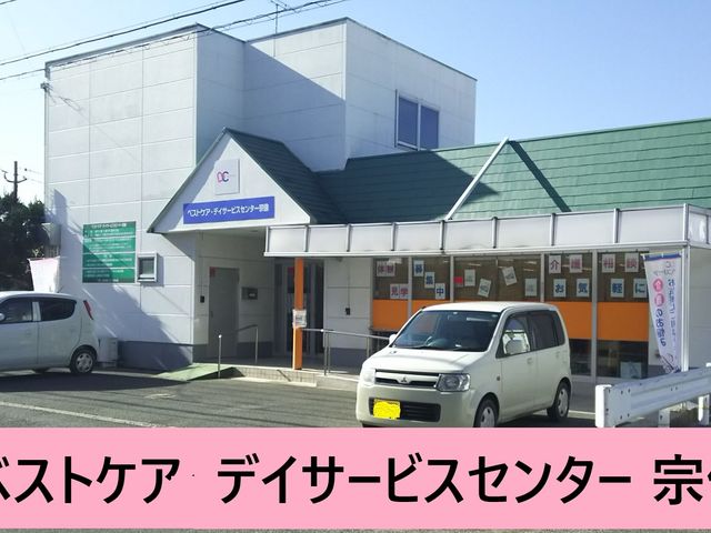 車両が停まる施設外観 外観 青い屋根と白い壁が印象的な建物です。車が施設の前に停まっています。