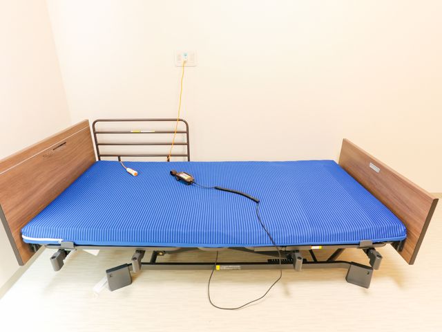 高機能ベッドの居室 居室 広々とした居室に設置されている、高さ調節が可能な電動ベッドです。安全で快適な生活をサポートする設備が整っています。