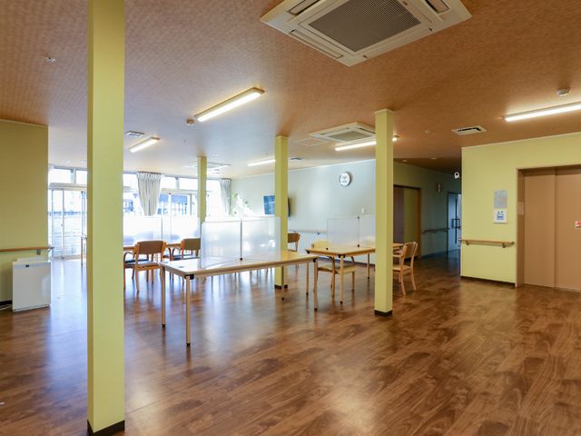 広々とした明るい食堂 共有スペース 天井が高く、窓から自然光が差し込む明るく広い食堂です。ゆとりを持って配置されたテーブルと椅子が、快適な食事時間を約束します。