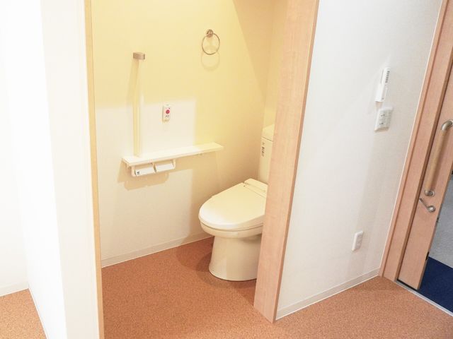 バリアフリーの洗面所 トイレ 手すり付きで安全性を考慮したトイレスペースです。清潔感があり、使いやすさが配慮されています。