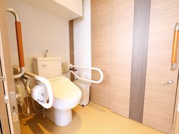 手すり付きの暖かみのあるトイレ
