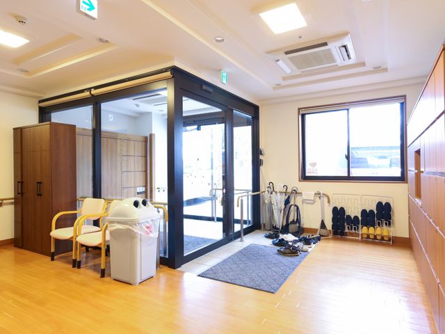 エントランスのプレゼンテーション 玄関 ゆとりある入口はスタッフと利用者の円滑な移動をサポートし、開放感ある空間が心地よい歓迎を促します。