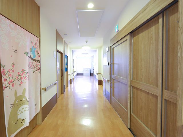 明るい廊下と和風ポスター 廊下 清潔感あふれる廊下は、和風デザインのポスターで温かみをプラスしており、患者様に安らぎを提供しています。