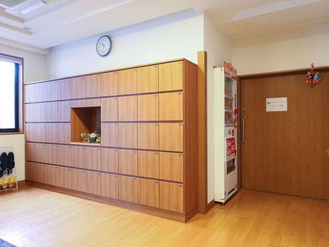整頓された木製シューズボックス 収納 エントランスには、居心地の良い木目のシューズボックスが設置されており、日常生活の快適さが保たれています。清潔感ある空間で、訪れる方々を温かく迎えます。